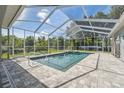 Relaxing screened-in pool area with a jacuzzi and brick-paved deck perfect for outdoor entertaining at 9431 Amidon St, Spring Hill, FL 34608