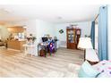 Open-concept living room featuring light wood floors, neutral walls, and ample natural light from large windows at 9630 Eldridge Rd, Spring Hill, FL 34608