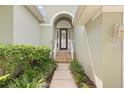 Inviting front entrance with tiled steps, well-maintained landscaping and glass accented front door at 1010 Teal Pointe, Tarpon Springs, FL 34689