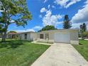 Charming single-story home with attached garage and a long concrete driveway at 10135 Glen Moor Ln, Port Richey, FL 34668