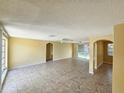 Spacious living room featuring tiled floors, ceiling fans, and arched doorways at 10135 Glen Moor Ln, Port Richey, FL 34668