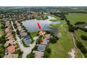 An aerial view of the property highlighting its position on a large pond in a lush and green area at 10342 Altrara Way, Trinity, FL 34655