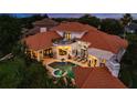 Back of house aerial view featuring an in-ground pool, a hot tub, and a second story balcony at 10342 Altrara Way, Trinity, FL 34655
