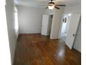 Spacious bedroom with hardwood floors, ceiling fan, and ample closet space at 1042 Howell Ave, Brooksville, FL 34601