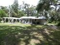 Expansive backyard features a covered patio and pergola, perfect for outdoor entertaining at 1042 Howell Ave, Brooksville, FL 34601