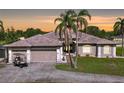 Beautiful single-story home with an attached three-car garage, palm trees and meticulous landscaping at 10941 Hilltop Dr, New Port Richey, FL 34654