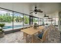 Enclosed patio area features a paver floor, ceiling fans, and views of the backyard pool and landscaping at 1104 Ketzal Dr, Trinity, FL 34655