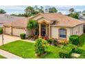 A lovely single-story home showcasing a well-kept lawn, mature trees, and an inviting front entrance at 11144 Brambleleaf Way, Hudson, FL 34667