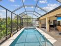A refreshing screened-in pool, perfect for relaxation and entertainment, adjacent to an outdoor seating area at 11144 Brambleleaf Way, Hudson, FL 34667