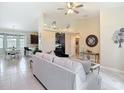 Open-concept living room featuring tile flooring, neutral decor, and views into the kitchen and dining areas at 12323 House Finch, Weeki Wachee, FL 34614