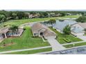 Beautiful aerial view of home overlooking a pond and golf course in a serene community at 1242 Almondwood Dr, Trinity, FL 34655