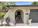 Welcoming front entrance with arched entryway, tiled walkway, and stylish outdoor lighting at 1376 Fayetteville Dr, Spring Hill, FL 34609