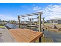Private wooden dock with a boat lift offering waterfront access and endless nautical adventures at 13821 Judy Ave, Hudson, FL 34667