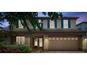 Two-story home at twilight featuring blue shutters, mature landscaping, and brick driveway at 1410 Halapa Way, Trinity, FL 34655