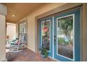 Inviting front porch with rocking chairs and a blue front door, offering a welcoming entrance to the home at 1410 Halapa Way, Trinity, FL 34655