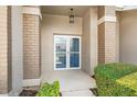 Covered front entryway with tiled brick support beams and double front doors at 1415 Pinewood Hills Ct, Spring Hill, FL 34606