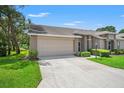 Charming single-story home with neutral color palette, well-maintained landscaping, and attached two car garage at 1415 Pinewood Hills Ct, Spring Hill, FL 34606