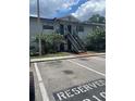 Condo complex with reserved parking and landscaping featuring a two story gray building at 203 Pine Violet Ct # 202, Tampa, FL 33612