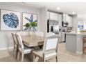 Elegant dining area with a wooden table, comfortable seating, and stylish decor leading into the kitchen at 272 Voltaire Dr, Spring Hill, FL 34609