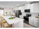 Modern kitchen featuring white cabinets, stainless steel appliances, and a large center island with seating at 272 Voltaire Dr, Spring Hill, FL 34609