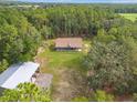 Aerial view of a charming home surrounded by lush greenery and trees in a rural area at 27295 Tarbel Rd, Brooksville, FL 34602