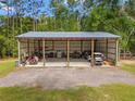 Large open air outbuilding with metal roof and gravel driveway surrounded by lawn and trees at 27295 Tarbel Rd, Brooksville, FL 34602