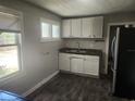 Functional kitchen with stainless steel refrigerator, updated cabinets, and wood look flooring at 3415 N 51St St, Tampa, FL 33619