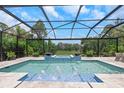 Inviting screened-in pool area complete with a spa and serene backyard views at 4287 Woodland Retreat Blvd, New Port Richey, FL 34655