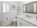 Bright bathroom features a marble vanity, modern fixtures, and a decorative framed mirror at 4716 Wolfram Ln, New Port Richey, FL 34653
