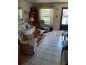 Bright living room featuring tile flooring, large windows, and comfortable seating arrangement at 6050 Chesham Dr # 3, New Port Richey, FL 34653