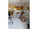 Cozy living room featuring tile flooring, a ceiling fan, and an open layout with views of the kitchen at 6050 Chesham Dr # 3, New Port Richey, FL 34653
