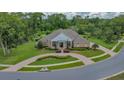 Aerial view of a brick home with circular driveway, well-maintained lawn, and lush surrounding trees at 7275 Crystal Spring Run, Weeki Wachee, FL 34607