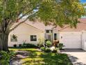 A close-up of villa facade and well-kept front lawn with mature landscaping creating a welcoming entry at 7518 Mediterranean Ct, Hudson, FL 34667