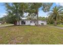 Inviting front of the home with a well-maintained lawn, mature trees and a long driveway at 8340 Saint Marks Ct, Hudson, FL 34667