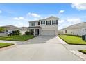 Inviting two-story home with well-maintained lawn, two-car garage, and classic black shutters. Large driveway at 8938 Bower Bass Cir, Wesley Chapel, FL 33545