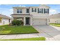 Inviting two-story home with well-maintained lawn, two-car garage, and classic black shutters at 8938 Bower Bass Cir, Wesley Chapel, FL 33545