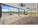 Spacious screened patio with brick pavers and ceiling fans offers a serene outdoor living space at 8938 Bower Bass Cir, Wesley Chapel, FL 33545