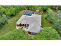 Aerial shot of the property showcasing the house, screened pool, and surrounding greenery at 9130 Madrid Rd, Weeki Wachee, FL 34613