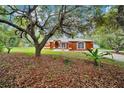 Home showcasing the lush landscaping and mature trees surrounding the property, with the house in the background at 9130 Madrid Rd, Weeki Wachee, FL 34613