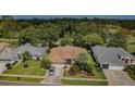 Aerial view of a single-story home with mature trees, well-manicured landscaping and a nearby golf course at 9719 Oakwood Hills Ct, New Port Richey, FL 34655
