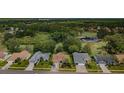 Wide aerial shot of a quiet residential street with well-kept homes and a lush golf course backdrop at 9719 Oakwood Hills Ct, New Port Richey, FL 34655