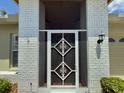 Close-up of front door with white brick and black details at 18142 Baywood Forest Dr, Hudson, FL 34667