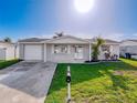 Inviting single-story home featuring a freshly painted exterior, attached garage, and well-kept front lawn at 10029 Freestone Ln, Port Richey, FL 34668