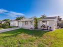 Well-maintained home with an attached garage, complemented by a green lawn and colorful landscaping at 10029 Freestone Ln, Port Richey, FL 34668