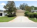 Well-maintained home features a two-car garage and mature landscaping at 10097 Holly Berry Dr, Weeki Wachee, FL 34613