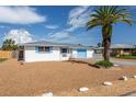 Charming home with a white exterior, blue shutters, a light blue garage door, and low maintenance landscaping at 10123 Oak Hill Dr, Port Richey, FL 34668