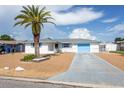 Charming home with a white exterior, blue shutters, a light blue garage door, and low maintenance landscaping at 10123 Oak Hill Dr, Port Richey, FL 34668