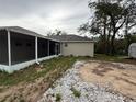 Back exterior view showcases a screen patio and the home's neutral color palette at 11308 Mahopac Rd, Weeki Wachee, FL 34614