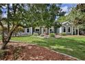 Well maintained front lawn showcasing mature trees, beautiful landscaping, and charming exterior details at 11510 Lakeview Dr, New Port Richey, FL 34654