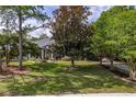 Landscaped front yard with trees, a well-manicured lawn, and a glimpse of the home at 11510 Lakeview Dr, New Port Richey, FL 34654